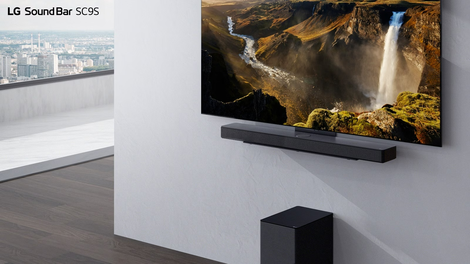 TV and LG Soundbar  SC9S are hung on a white wall. Below a black wireless subwoofer is placed on the floor. Beyond the window on the left a city view with the blue sky can be found.